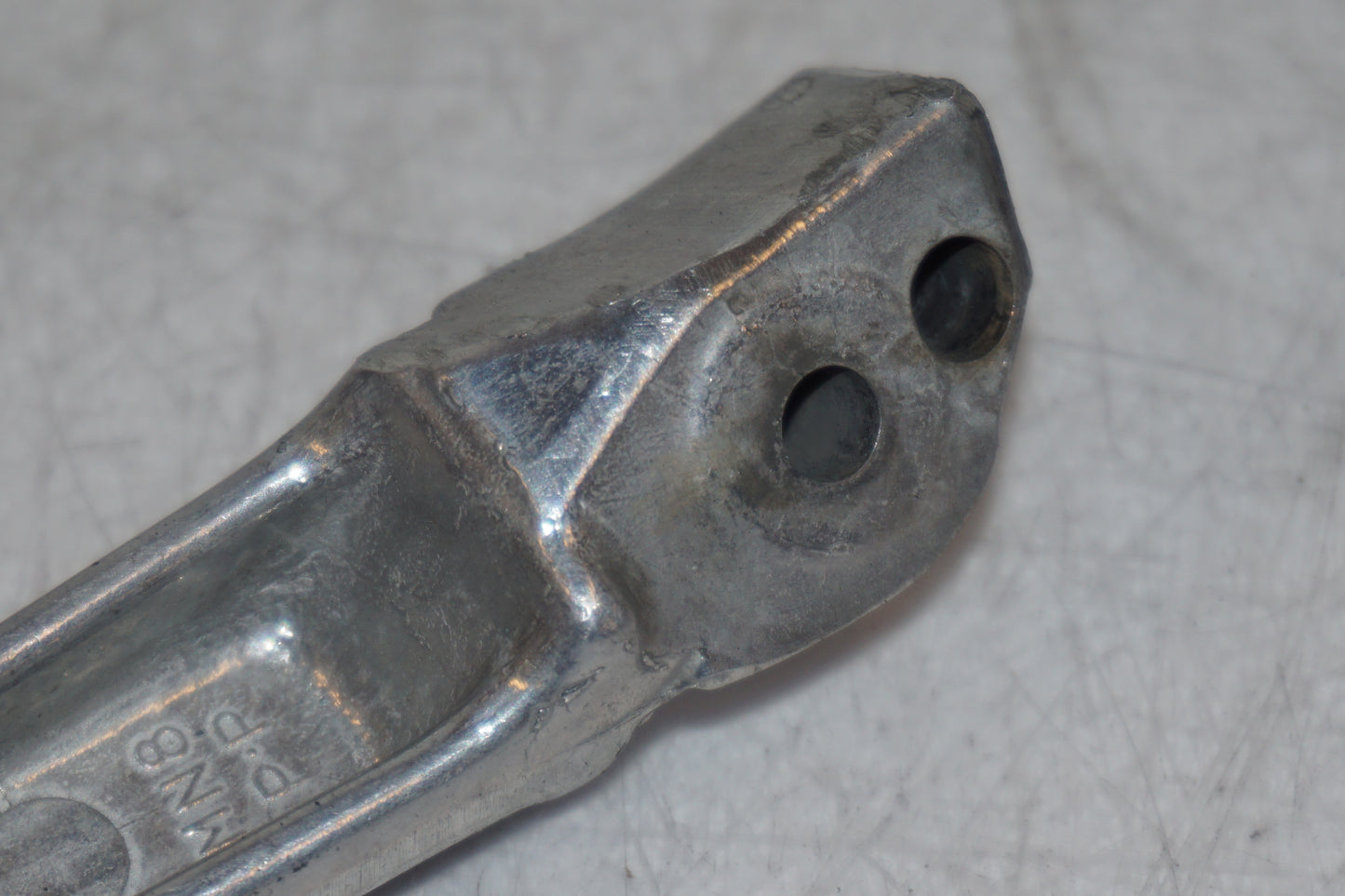 Snett uppifrån på <p>Fotpinne höger bak från Honda VFR 750 F 1995.</p>
<p>Små märken på undersidan. Okej skick.</p> motorcykel.