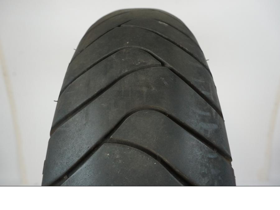 Baksidan på <p>Däck: Michelin Pilot Road.</p>
<p>Dimension: 160/60-ZR18 M/C (70W).</p>
<p>Tillv. 0402.</p>
<p>Mönsterdjup: ca. 40 %, plattslitet.</p> motorcykel.