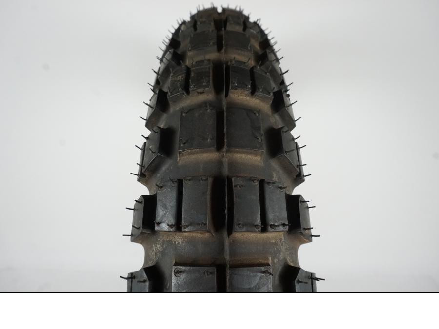 Baksidan på <p>Däck: Metzeler MCE Karoo 2(T).</p>
<p>Dimension: 110/80-19 M/C 59Q M S.</p>
<p>Tillv. 1811.</p>
<p>Mönsterdjup: 100 %.</p> motorcykel.