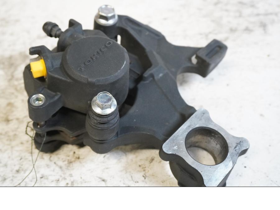 Framsidan på <p>Bromsok bak från Suzuki GSX-R 750 2009.</p>
<p>Tokico 1-kolv.</p> motorcykel.