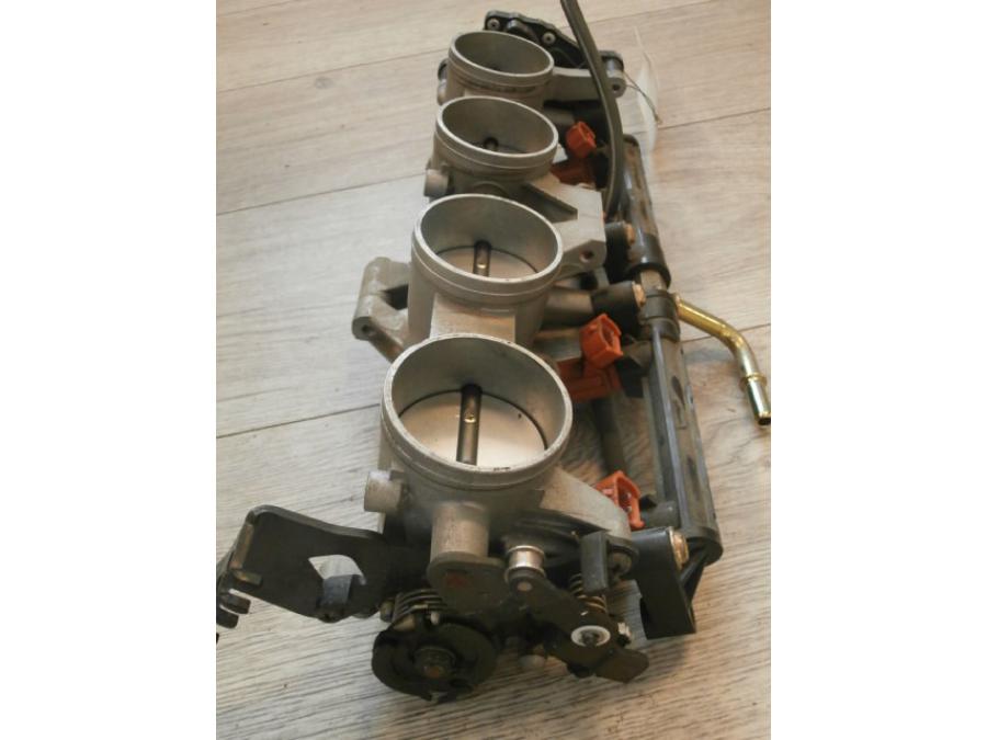 Snett nerifrån på <p>Spjällhus från Suzuki GSX-R 600 2004.</p>
<p>Komplett.</p> motorcykel.