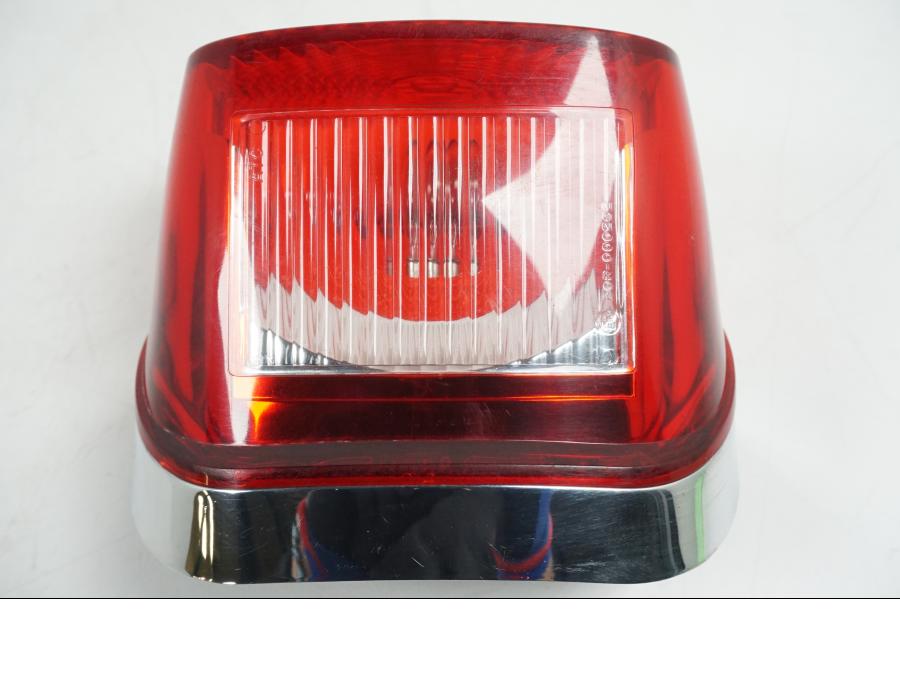 Vänster sida på <p>Baklampa från HD Sportster XL 1200 Custom 1999. </p>
<p>Med fästplatta 68066-99. OBS skruvar som håller glaset saknas. Förövrigt bra skick.</p> motorcykel.