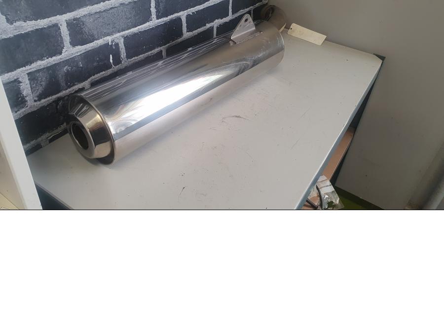 Baksidan på <p>Ljuddämpare från Honda VFR 800 2000.</p>
<p>Original. En mindre buckla samt ytliga repor finns.</p> motorcykel.