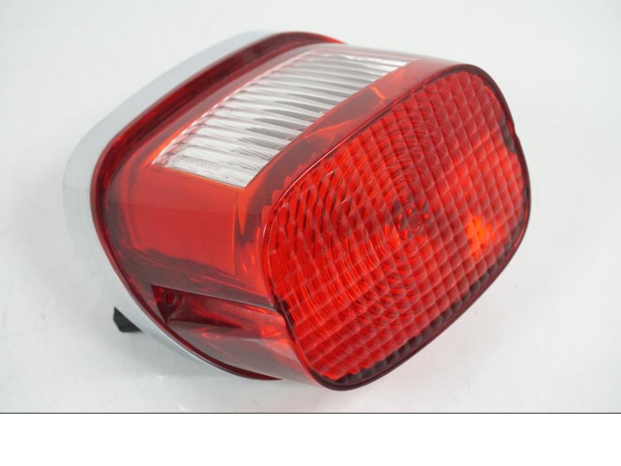 Framsidan på <p>Baklampa från HD Sportster XL 1200 Custom 1999. </p>
<p>Med fästplatta 68066-99. OBS skruvar som håller glaset saknas. Förövrigt bra skick.</p> motorcykel.