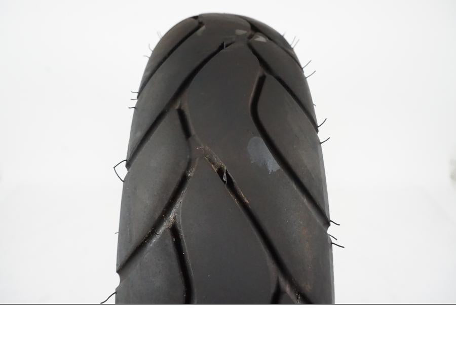 Baksidan på <p>Däck: Kenda.</p>
<p>Dimension: 120/80-14 M/C 58P.</p>
<p>Tillv. 5218.</p>
<p>Mönsterdjup: ca. 70 %.</p> motorcykel.