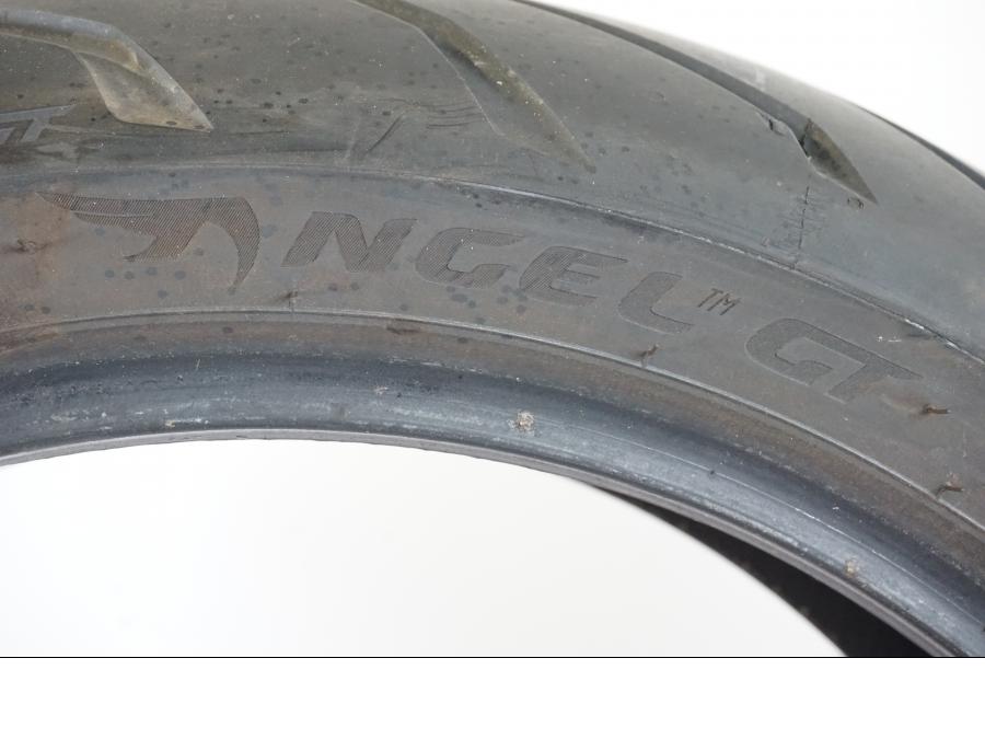 Snett uppifrån på <p>Begagnad däck av märket Pirelli och modell Gran Turismo Angel GT.</p>
<p>Dimension 180/55 ZR 17 M/C (73W). </p>
<p>Mönsterdjup ca: (5,30mm i mitten) (4,35mm yttre däck) ca 80% kvar.</p>
<p>Tillv 1821.</p>
<p>Mindre märke finns se bild.</p> moped.