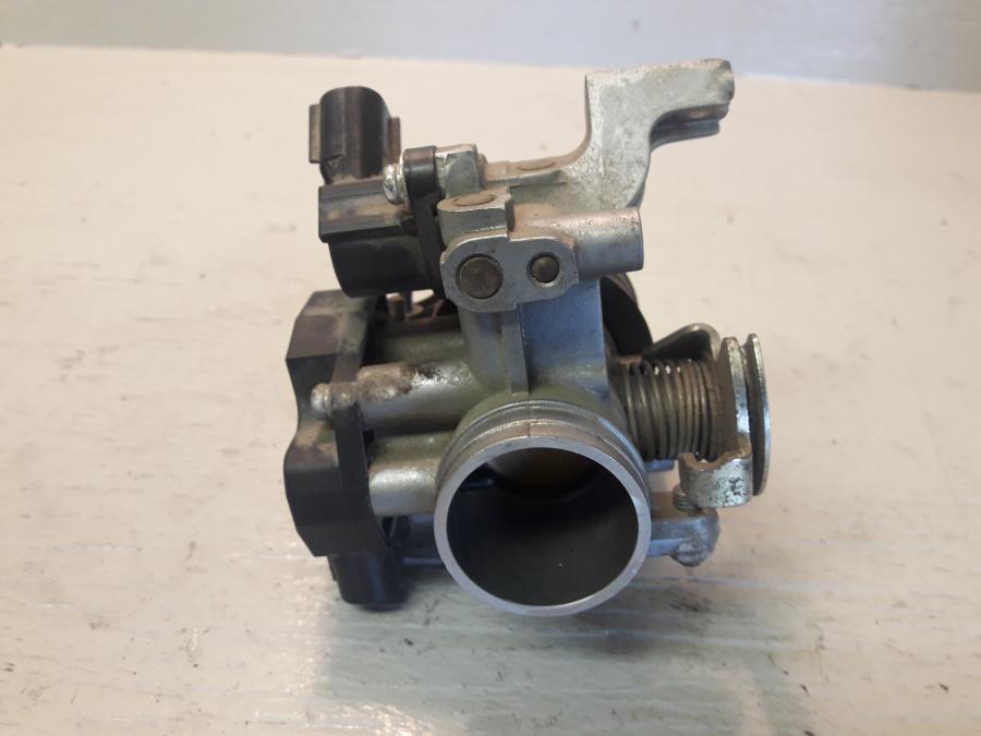 Vänster sida på Spjällhus från en Yamaha WR 125 -2010 motorcykel.