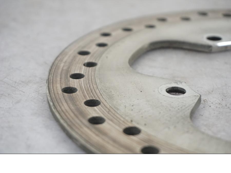 Snett nerifrån på Bromsskiva från en Triumph Tiger -2009 motorcykel.