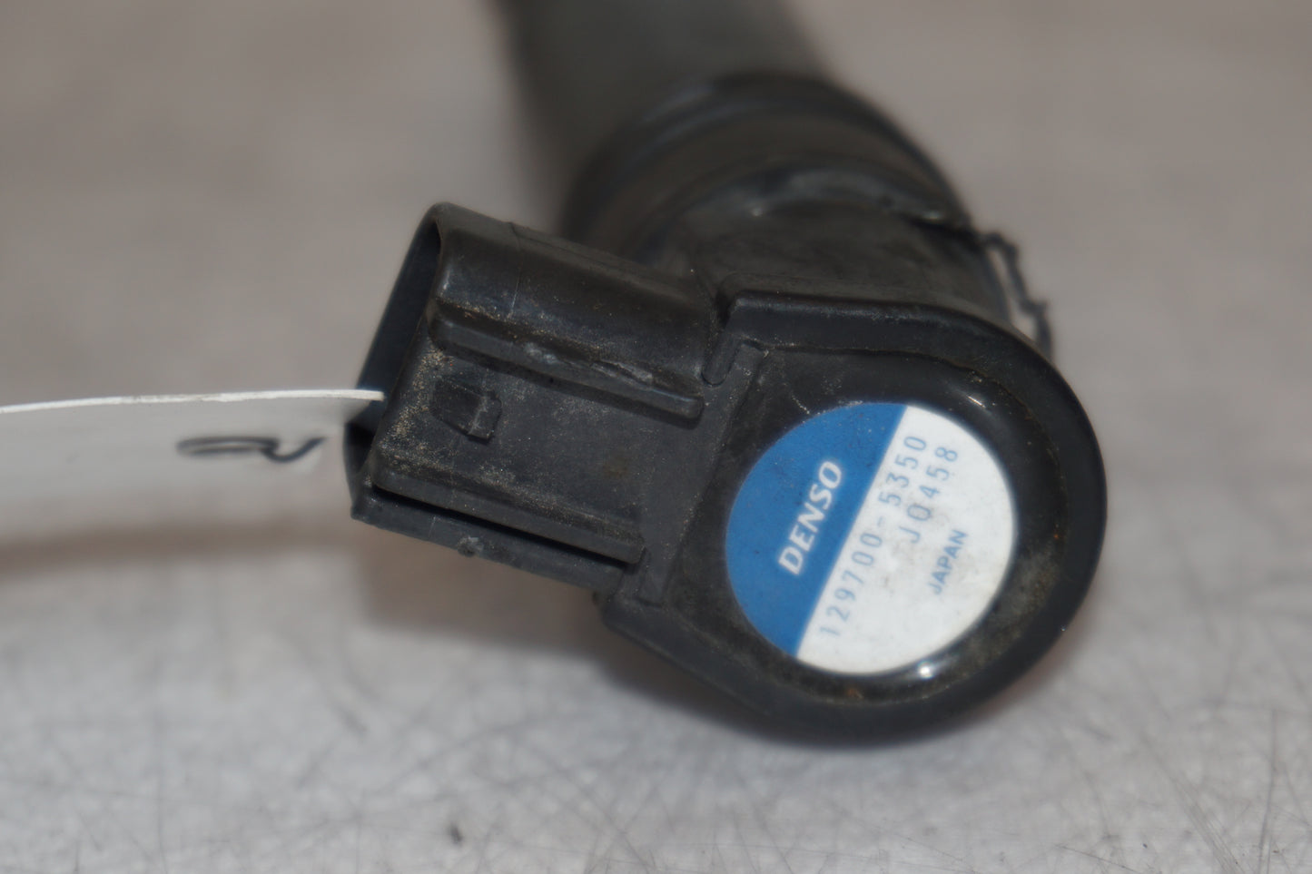 Snett nerifrån på <p>Tändspole höger från Kawasaki ER-6N ABS.</p>

<p>Denso 129700-5359.</p> motorcykel.