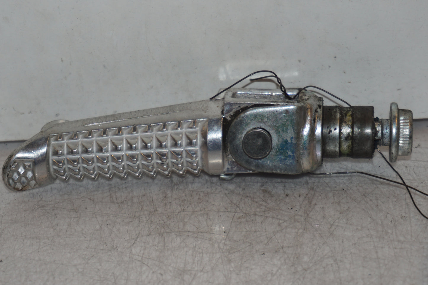 Framsidan på <p>Fotpinne vänster fram från Suzuki GSX-S 1000 2015.</p>

<p>Utan slitpig.</p> motorcykel.