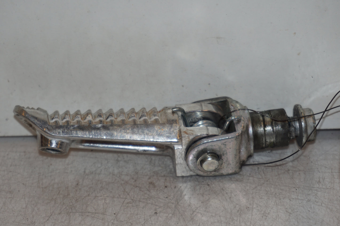 Baksidan på <p>Fotpinne vänster fram från Suzuki GSX-S 1000 2015.</p>

<p>Utan slitpig.</p> motorcykel.