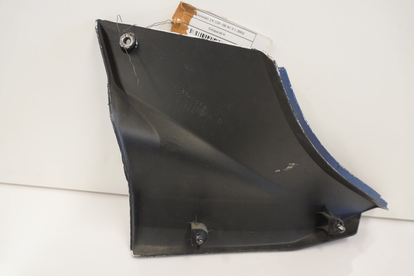 Baksidan på <p>Sidopanel höger från Kawasaki ZX-10R 2006.</p>

<p>Under sadel, små repor</p> motorcykel.
