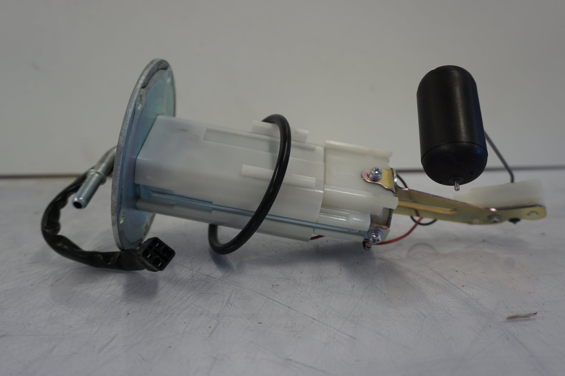 Snett nerifrån på <p>Bensinpump insprut från Kawasaki ER-6N ABS 2014.</p>

<p>Med nivågivaren</p> motorcykel.