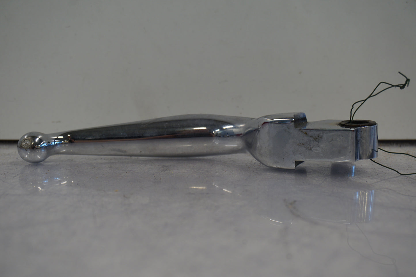 Baksidan på <p>Bromshandtag höger.</p>

<p>Krom.</p> motorcykel.