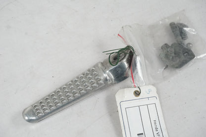 Framsidan på <p>Fotpinne vänster bak från Honda VFR 750 F 1995.</p>

<p>Okej skick.</p> motorcykel.