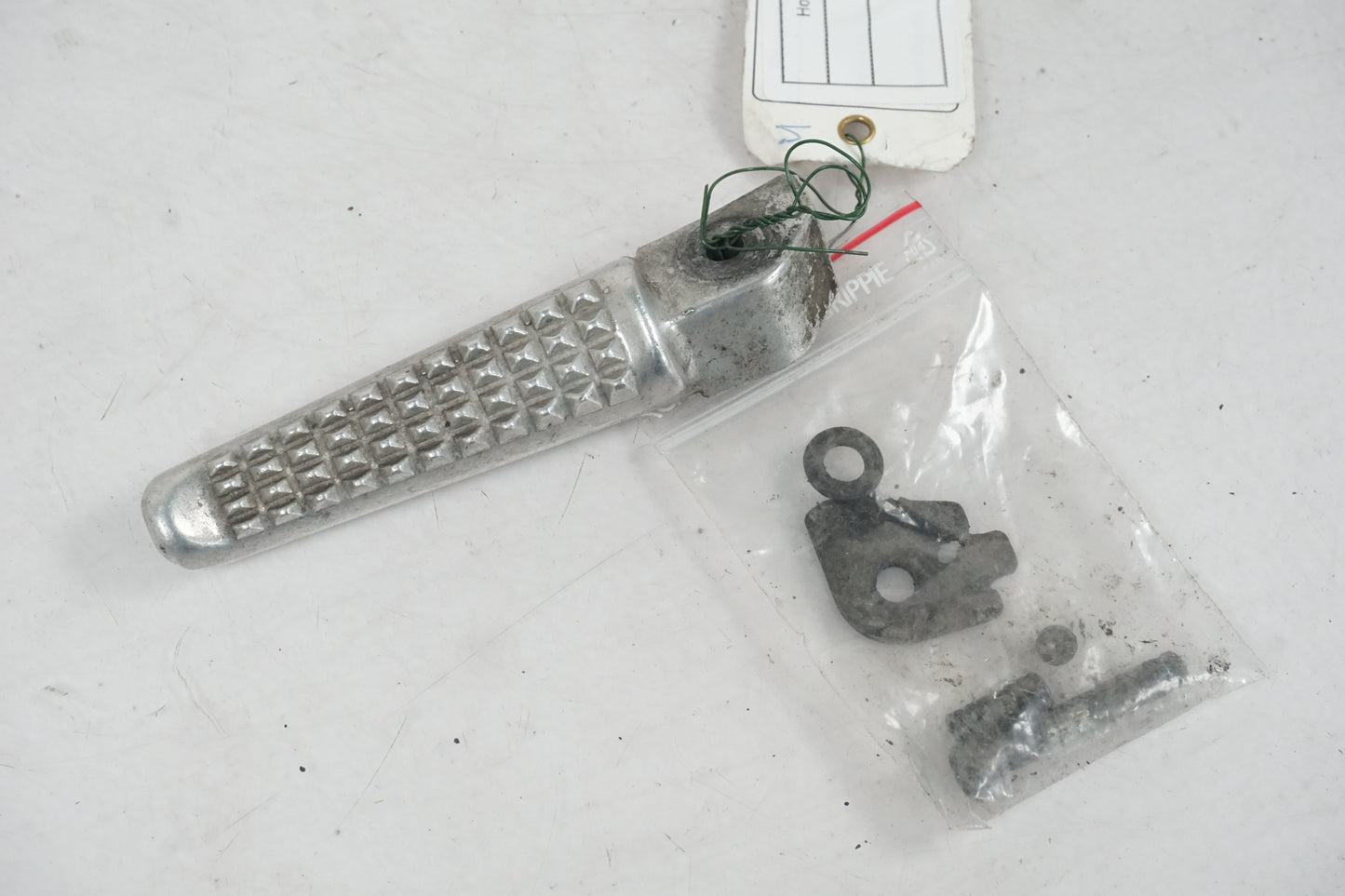 Framsidan på <p>Fotpinne vänster bak från Honda VFR 750 F 1990.</p>

<p>Okej skick.</p> motorcykel.