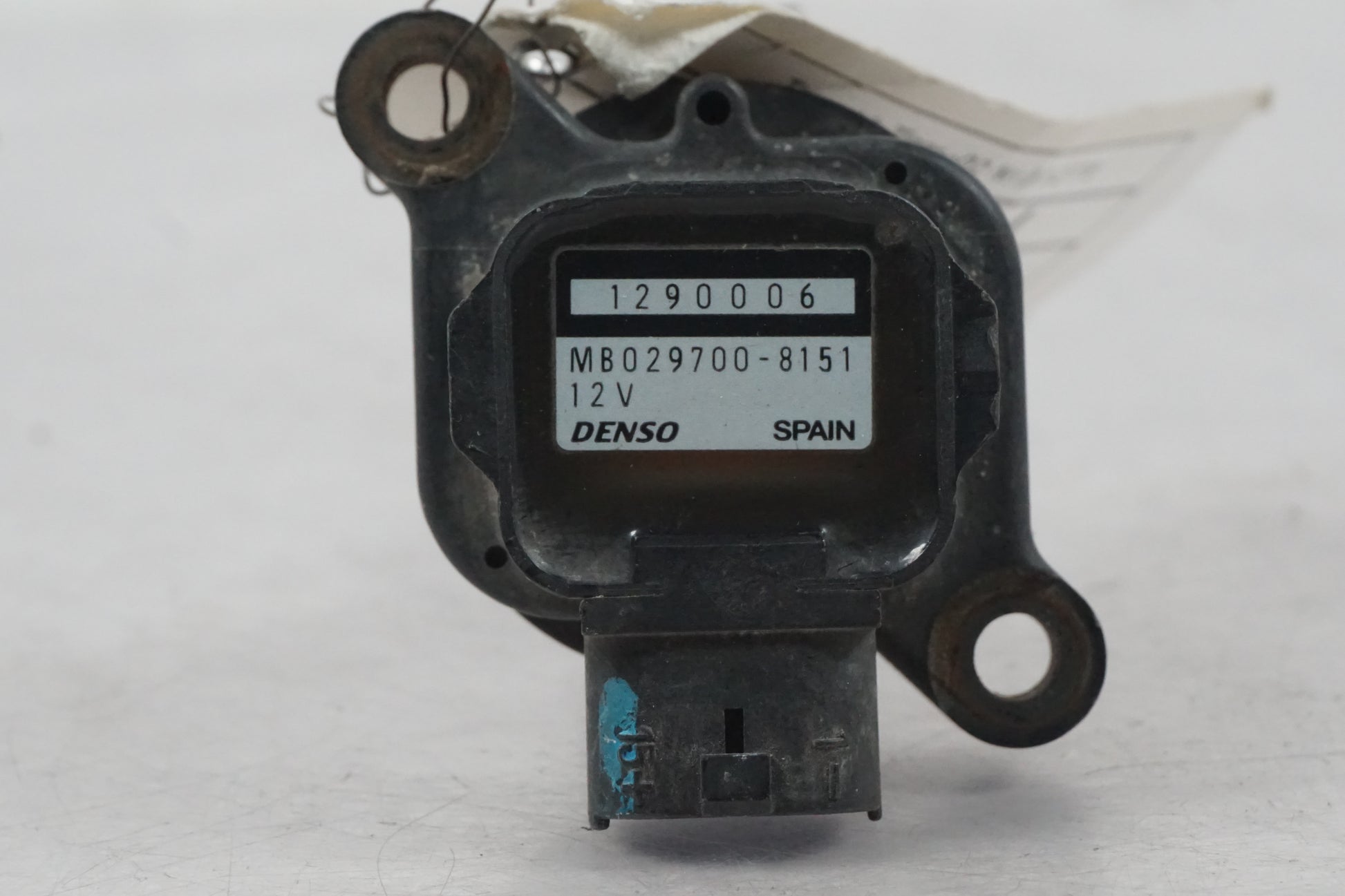 Baksidan på <p>Tändspole från Triumph Tiger 2002.</p>

<p>Denso 1290006 MB029700-8151 12V 0,6ohm - 1</p> motorcykel.