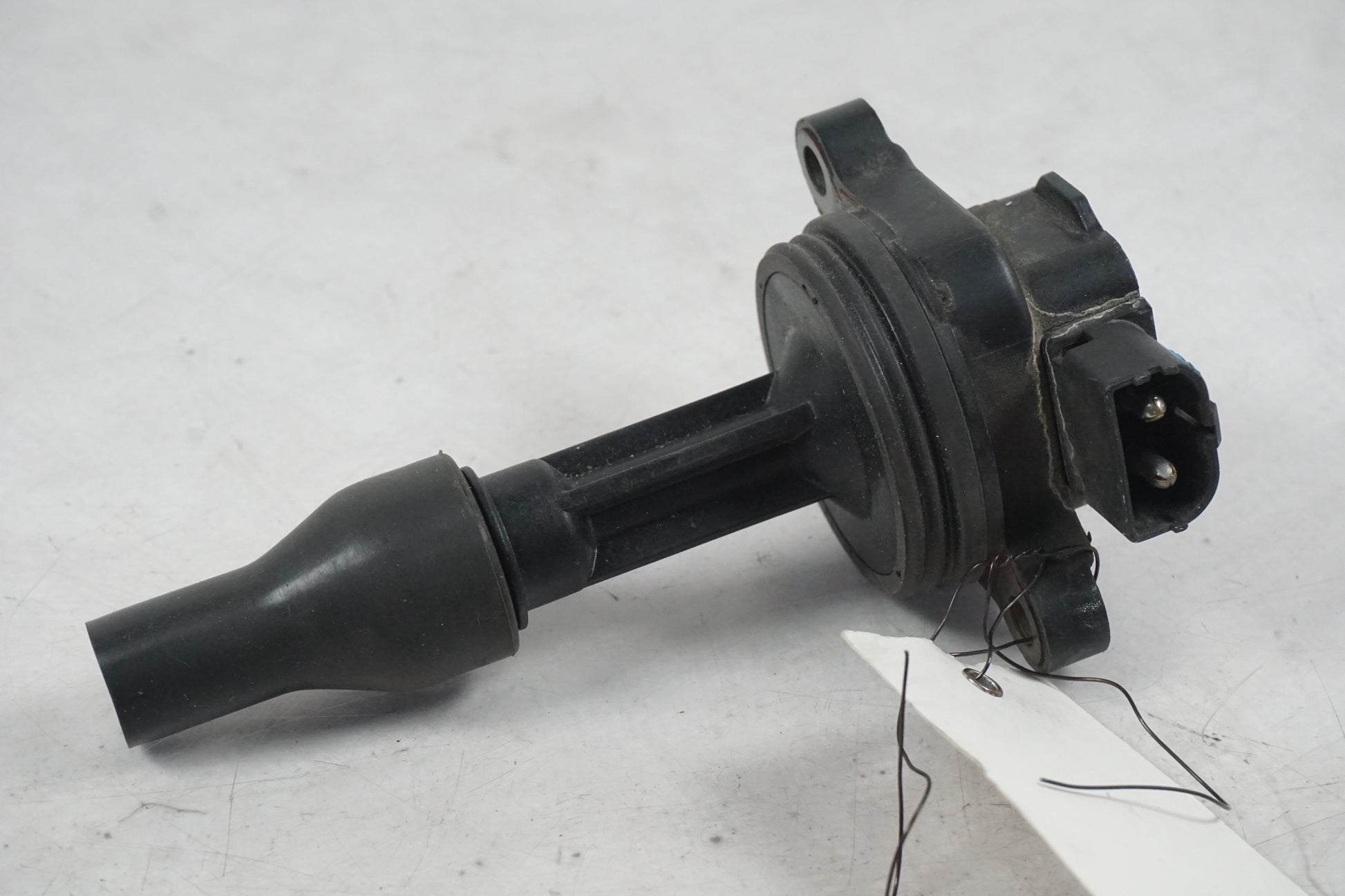 Framsidan på <p>Tändspole från Triumph Tiger 2002.</p>

<p>Denso 1290006 MB029700-8151 12V 0,6ohm - 2</p> motorcykel.