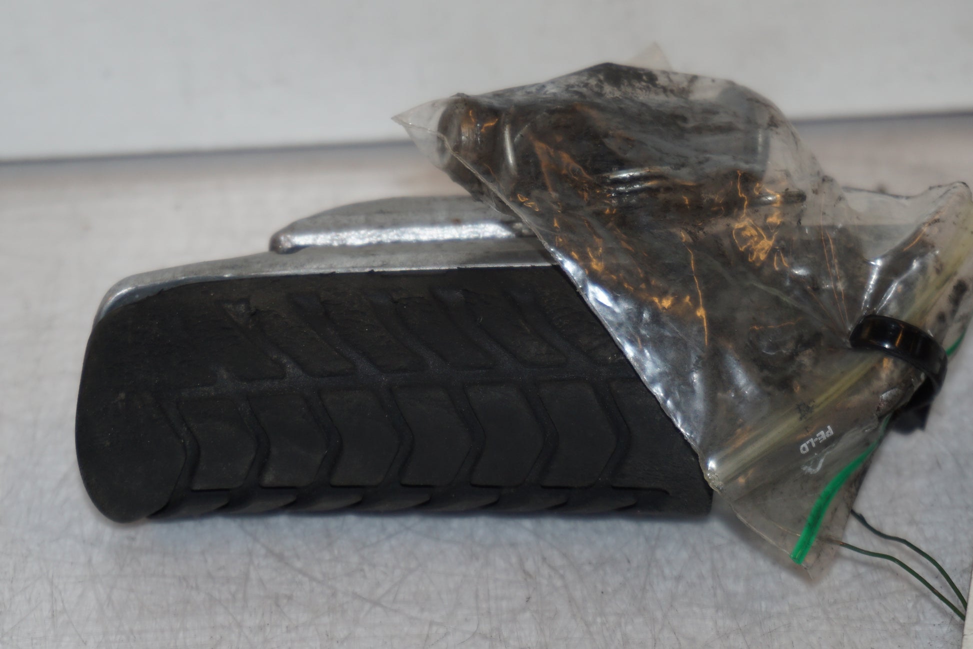 Framsidan på <p>Fotpinne vänster fram från Kawasaki Z 900 2017.</p>

<p>Lite skrap under. Okej skick.</p> motorcykel.