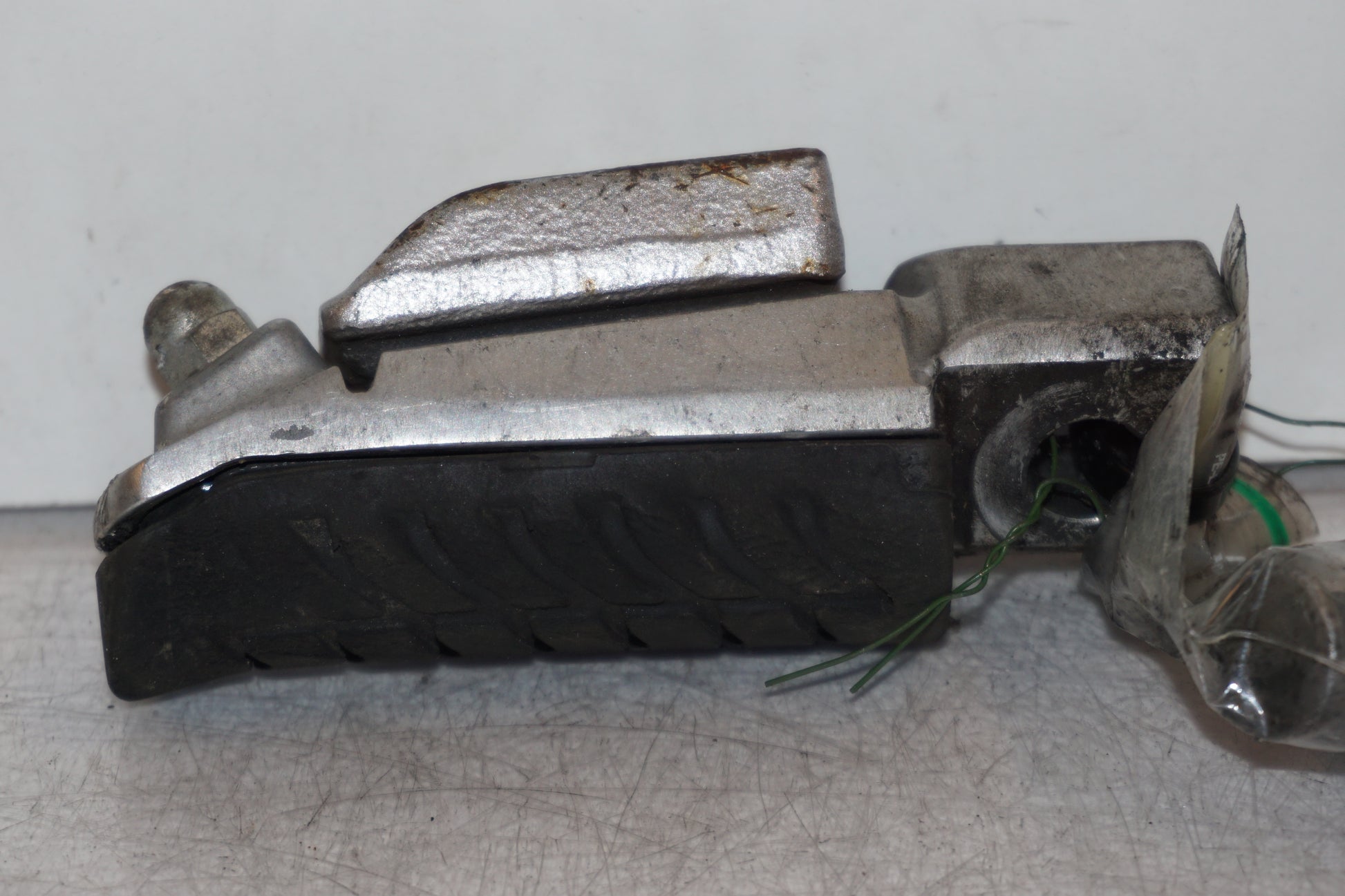 Vänster sida på <p>Fotpinne vänster fram från Kawasaki Z 900 2017.</p>

<p>Lite skrap under. Okej skick.</p> motorcykel.