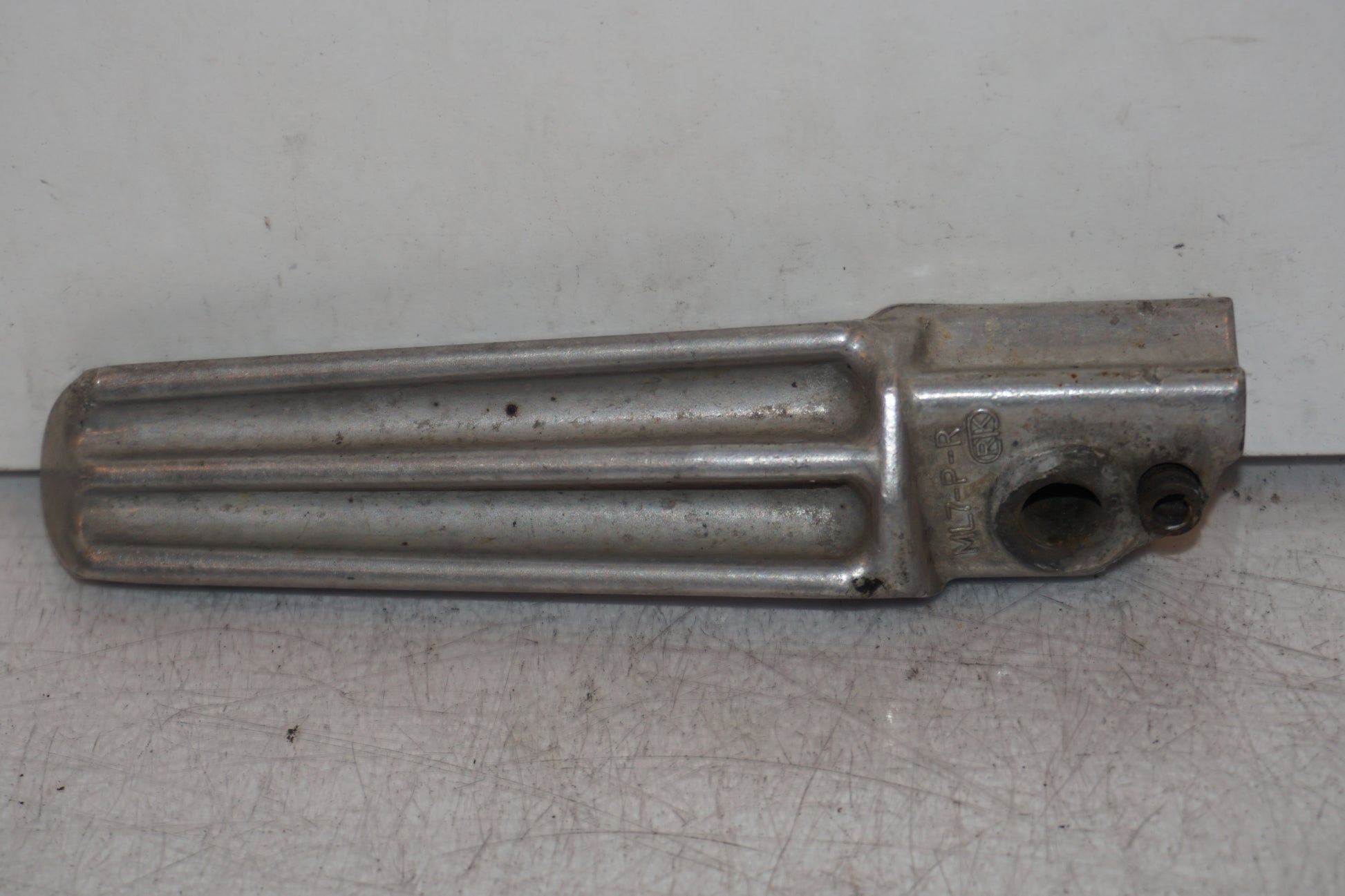 Baksidan på <p>Fotpinne höger bak från Honda VFR 750 F 1988.</p>

<p>Okej skick.</p> motorcykel.