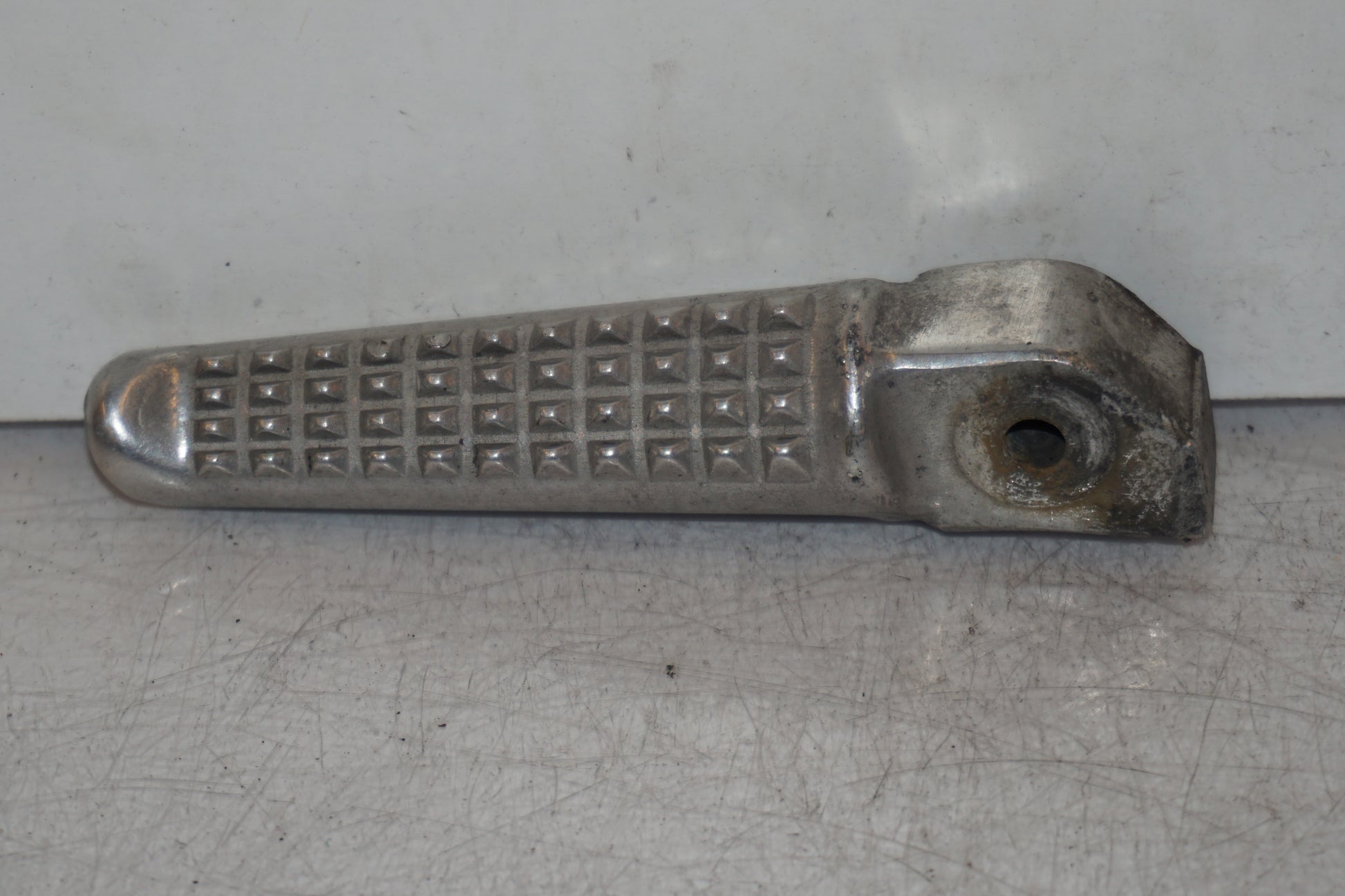 Framsidan på <p>Fotpinne höger bak från Honda VFR 750 F 1994.</p>

<p>Okej skick.</p> motorcykel.