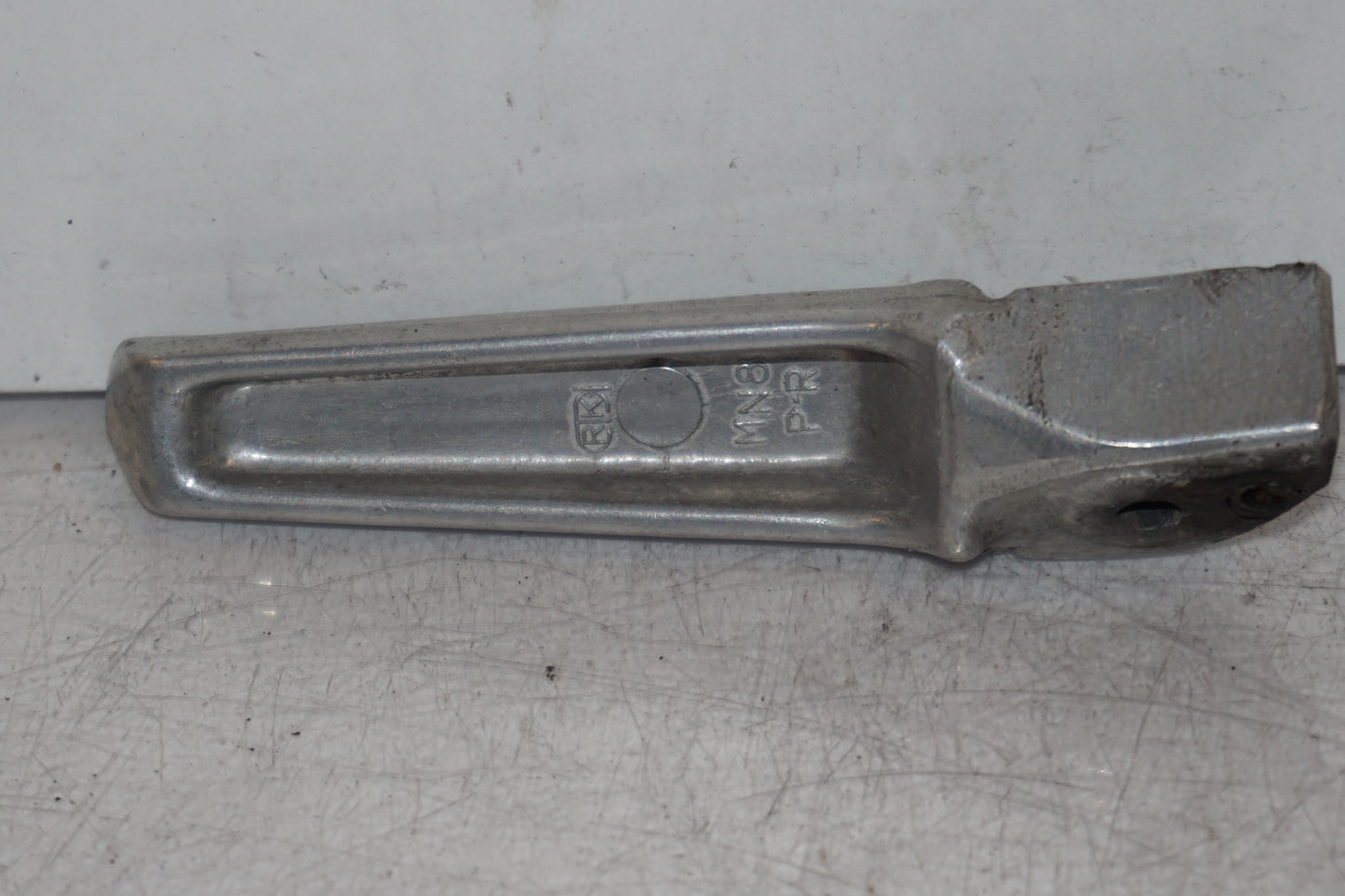 Baksidan på <p>Fotpinne höger bak från Honda VFR 750 F 1994.</p>

<p>Okej skick.</p> motorcykel.