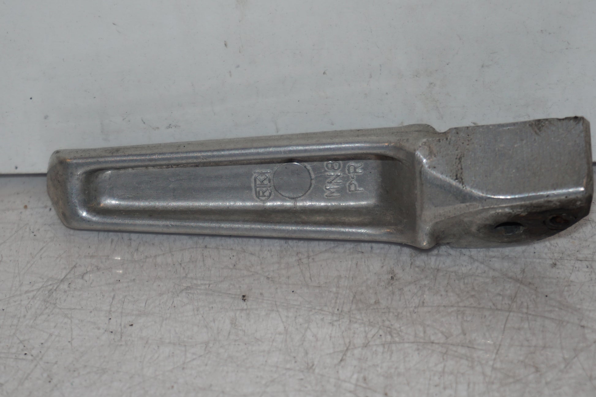 Baksidan på <p>Fotpinne höger bak från Honda VFR 750 F 1994.</p>

<p>Okej skick.</p> motorcykel.