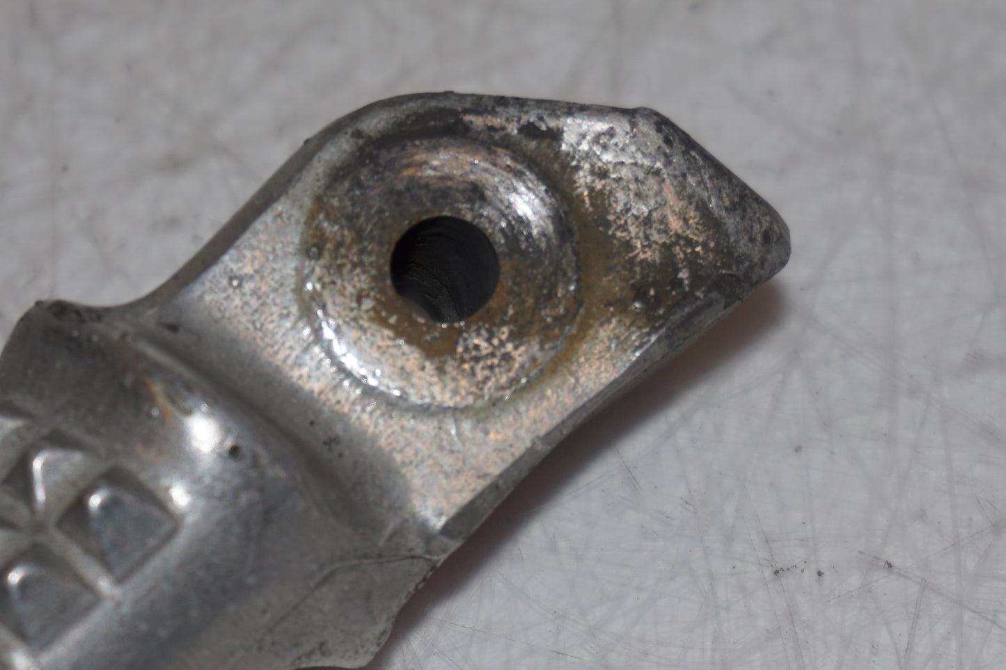 Snett nerifrån på <p>Fotpinne höger bak från Honda VFR 750 F 1994.</p>

<p>Okej skick.</p> motorcykel.