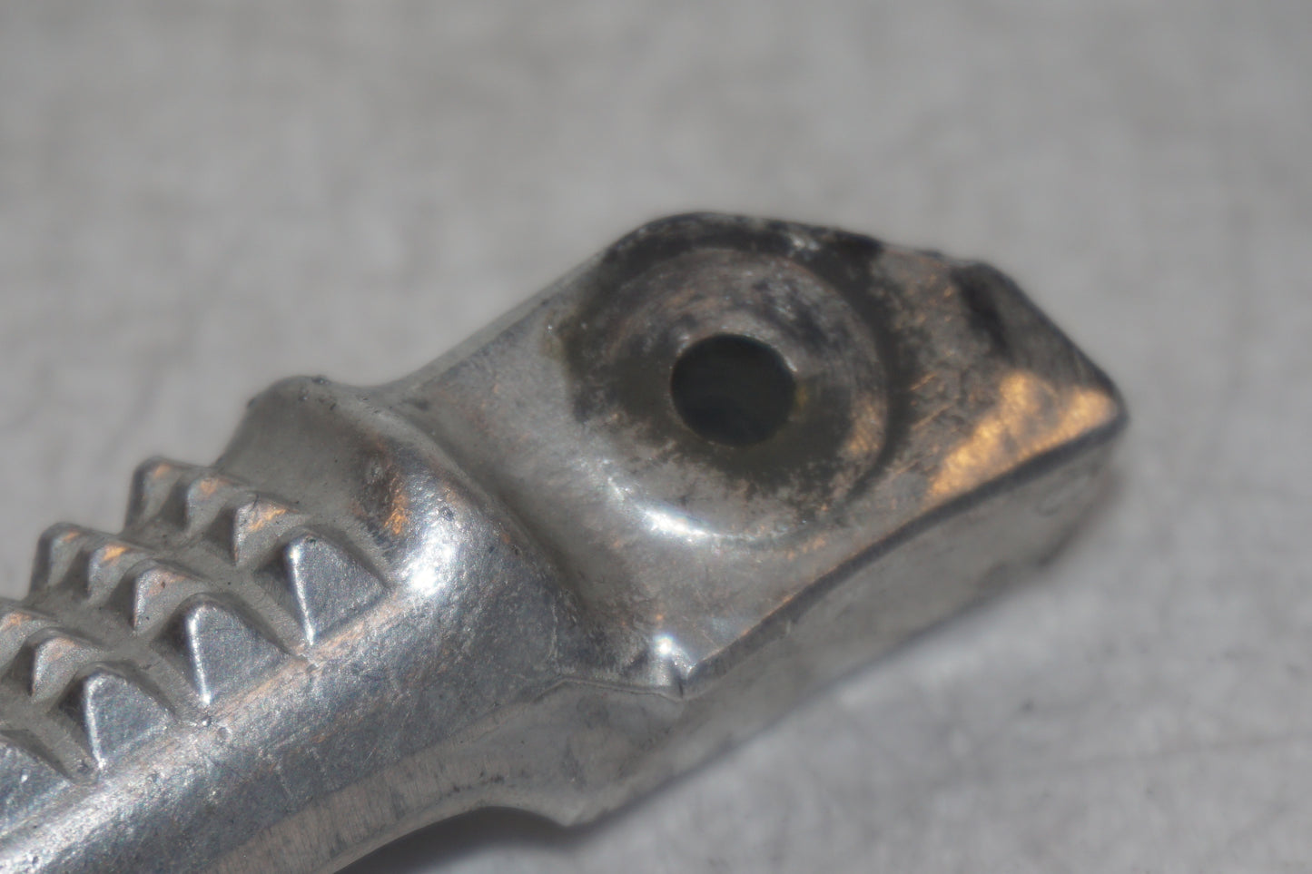 Vänster sida på <p>Fotpinne höger bak från Honda VFR 750 F 1995.</p>

<p>Små märken på undersidan. Okej skick.</p> motorcykel.