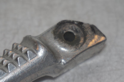 Vänster sida på <p>Fotpinne höger bak från Honda VFR 750 F 1995.</p>

<p>Små märken på undersidan. Okej skick.</p> motorcykel.