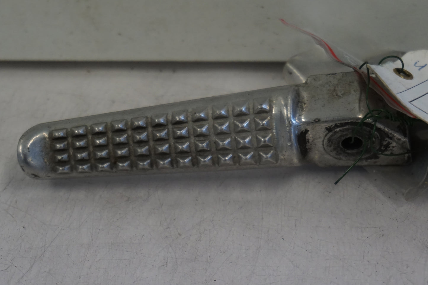 Framsidan på <p>Fotpinne höger bak från Honda VFR 750 F 1990.</p>

<p>Okej skick.</p> motorcykel.