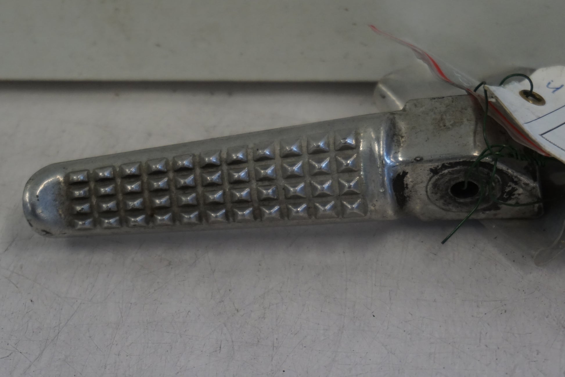 Framsidan på <p>Fotpinne höger bak från Honda VFR 750 F 1990.</p>

<p>Okej skick.</p> motorcykel.