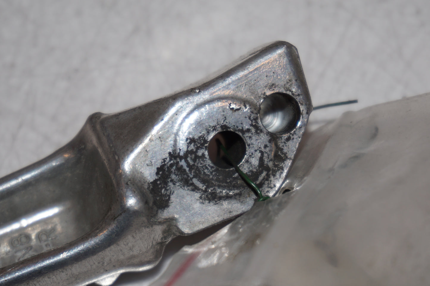 Snett nerifrån på <p>Fotpinne höger bak från Honda VFR 750 F 1990.</p>

<p>Okej skick.</p> motorcykel.