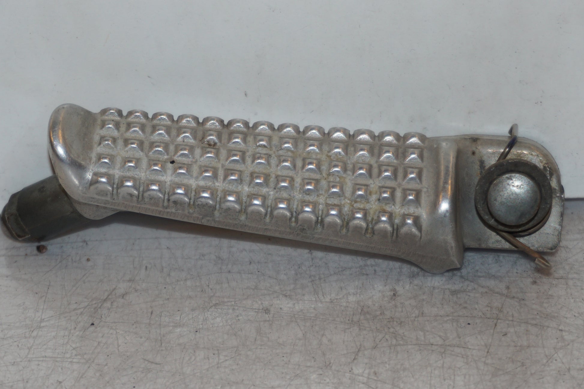 Framsidan på <p>Fotpinne vänster fram från Honda VFR 750 F 1988.</p>

<p>Okej skick.</p> motorcykel.