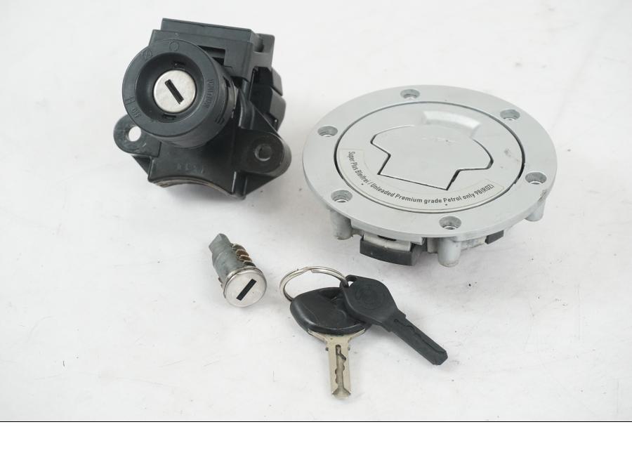 Framsidan på <p>Låssats från BMW K 1200 R Sport 2007.</p>

<p>1st nyckel och en plastkopia, sadellås, tanklock, tändningslås (saknas plastbit vid en av kontakterna).</p> motorcykel.