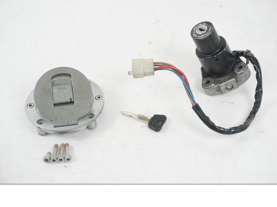 Framsidan på <p>Låssats från Yamaha FJ 1200 1986.</p>

<p>Tändningslås. Tanklock, 1st nyckel.</p>

<p>Repor och slitage av lack på tändningslåset samt att gummiskyddet för vajrarna har ett mindre hål se bilder.</p> motorcykel.