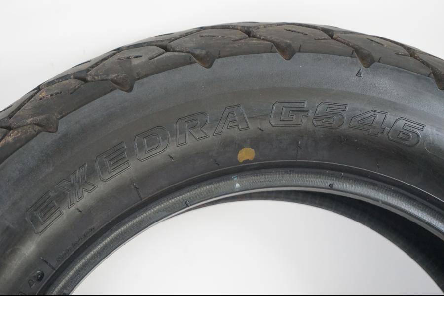 Vänster sida på <p>Begagnad däck av märket Bridgestone och modell Exedra G546.</p>

<p>Dimension 170/80-15 M/C 77S. </p>

<p>Mönsterdjup ca: 4,00mm.</p>

<p>Mönsterdjup yttre kanter ca: 5,40mm.</p>

<p>Tillv: Vecka 44 år 2014.</p> moped.