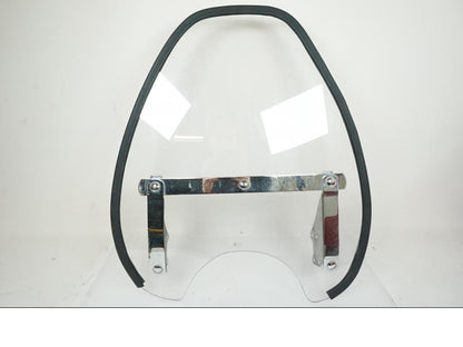 Framsidan på <p>Vindruta från Suzuki VZ 800 2000.</p>

<p>Fästen finns ej, skrapmärke på kromdetalj se bilder, rutfästena är original men vindrutan är hemmagjord. Ytliga repor finns på rutan se bilder.</p> motorcykel.