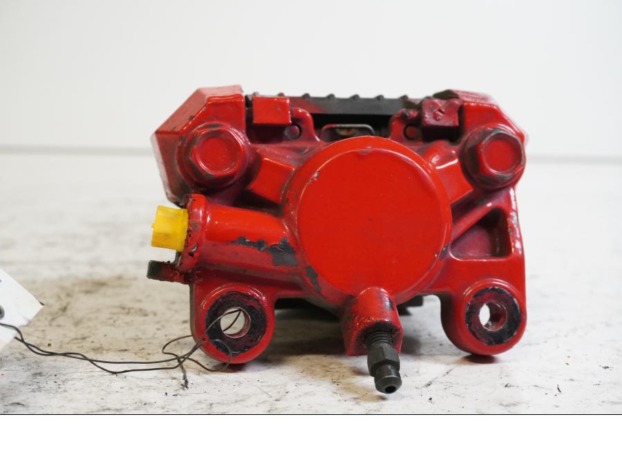 Baksidan på <p>Bromsok bak från Suzuki GSX-R 750 W 1995.</p>

<p>Tokico 2-kolv, rödmålad.</p> motorcykel.