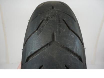 Baksidan på <p>Däck: Dunlop D407T Harley Davidson.</p>

<p>Dimension: 180/65B16 M/C 81H.</p>

<p>Tillv. 4817.</p>

<p>Mönsterdjup: ca. 40 %, plattslitet och torrsprickor finns.</p> motorcykel.