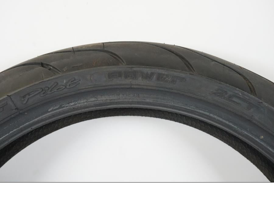 Baksidan på <p>Begagnad däck av märket Michelin och modell Pilot Power 2CT.</p>

<p>Dimension 120/65-17.</p>

<p>Mönsterdjup ca: 60% (3,50mm).</p>

<p>Tillv 1022.</p> moped.