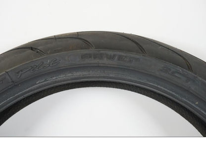Baksidan på <p>Begagnad däck av märket Michelin och modell Pilot Power 2CT.</p>

<p>Dimension 120/65-17.</p>

<p>Mönsterdjup ca: 60% (3,50mm).</p>

<p>Tillv 1022.</p> moped.