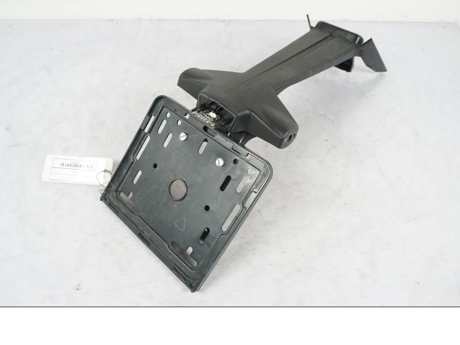 Framsidan på <p>Skylthållare till KTM 125 Duke.</p>

<p>Saknar lampglaset!</p> motorcykel.