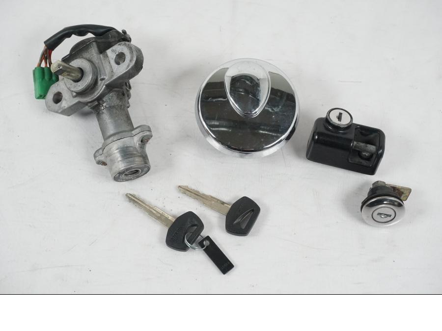 Framsidan på <p>Låssats från Suzuki VL 800 2004.</p>

<p>Tändningslås, tanklock, hjälmlås, lucklås och 2st nycklar.</p> motorcykel.