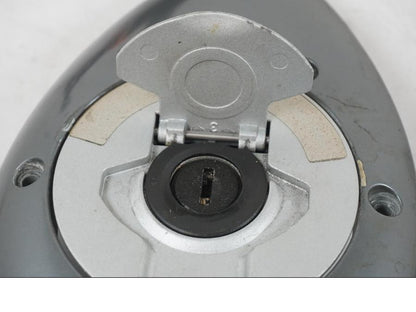 Snett uppifrån på <p>Låssats från BMW R 1200 C 2002.</p>

<p>Tändningslås, tanklock, ett väsklås, skador finns och 2st nycklar. Lacksläpp på tändningslåset se bild.</p> motorcykel.