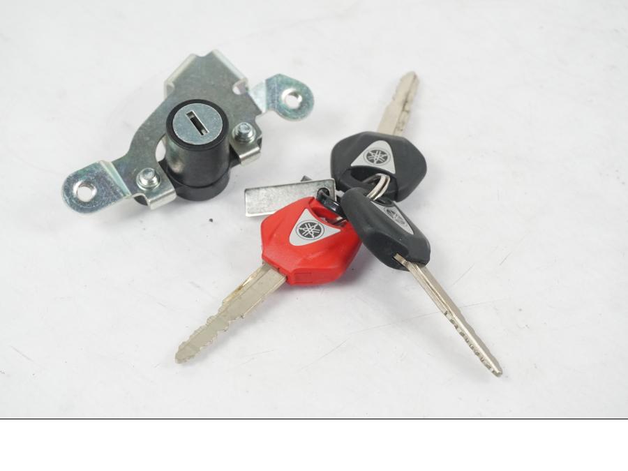 Baksidan på <p>Låssats från Yamaha MT-09 Tracer ABS 2016.</p>

<p>Tändningslås, antenn, cdi/ecu (2SC-8591A-00), tanklock, sadellås, 1st röd nyckel och 2st svarta nycklar</p> motorcykel.