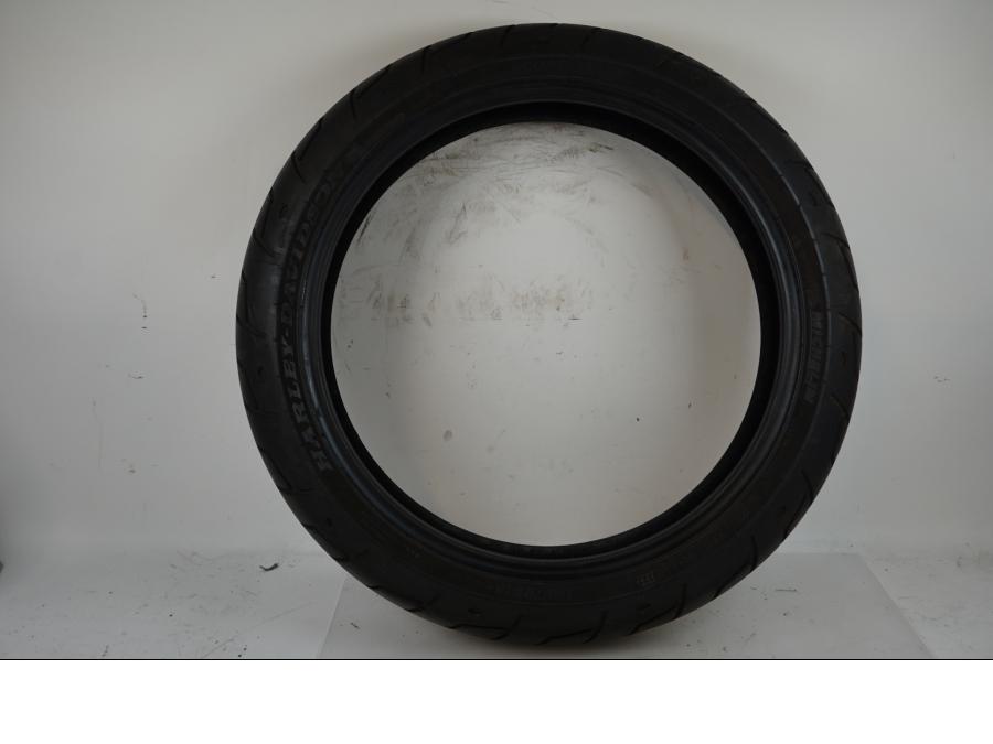 Framsidan på <p>Begagnad däck av märket Michelin och modell Scorcher "31" Harley Davidson.</p>

<p>Dimension 130/70-18.63H </p>

<p>Mönsterdjup ca.4mm 70%</p>

<p>Tillv.03/2022</p> moped.