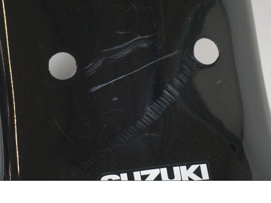 Snett nerifrån på <p>Bakskärm från Suzuki VL 800 2007.</p>

<p>Två sprickor i bakkant, repor och mindre slitage av lack finns se bilder.</p> motorcykel.