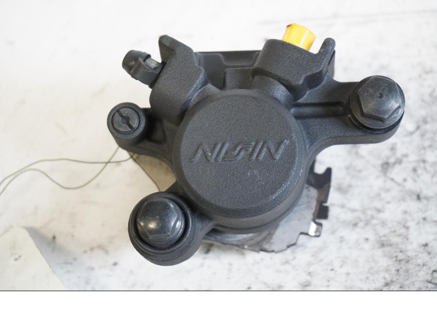 Framsidan på <p>Bromsok bak från Yamaha YZF 1000 R1 2009.</p>

<p>Nissin. Ett kolvs ok.</p> motorcykel.